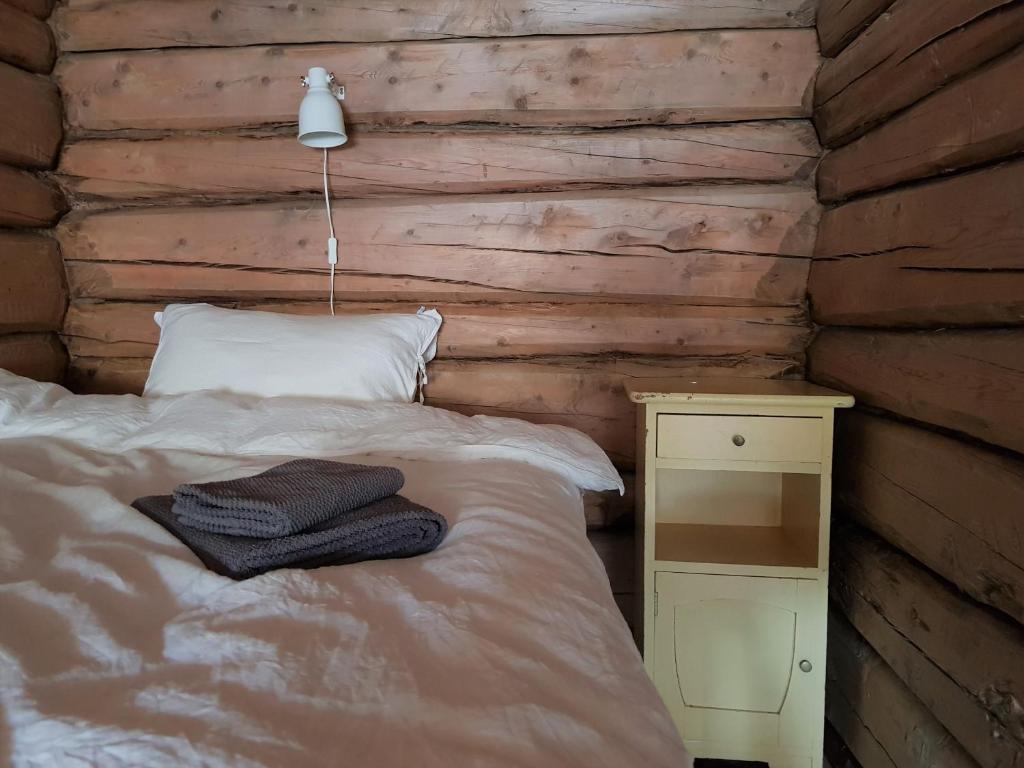 ein Schlafzimmer mit einem Bett und einer Holzwand in der Unterkunft Bakarstuo, Utpå Neset in Trofors