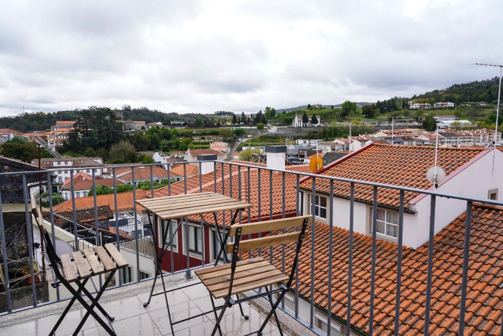 een balkon met 2 stoelen en uitzicht op de stad bij Casa Portas 8&10 in Lamego