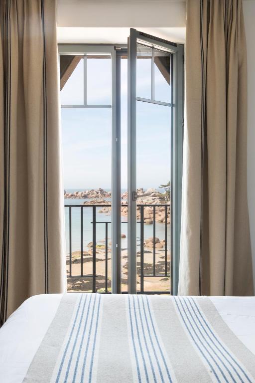 a bedroom with a bed and a view of the ocean at Castel Beau Site in Perros-Guirec
