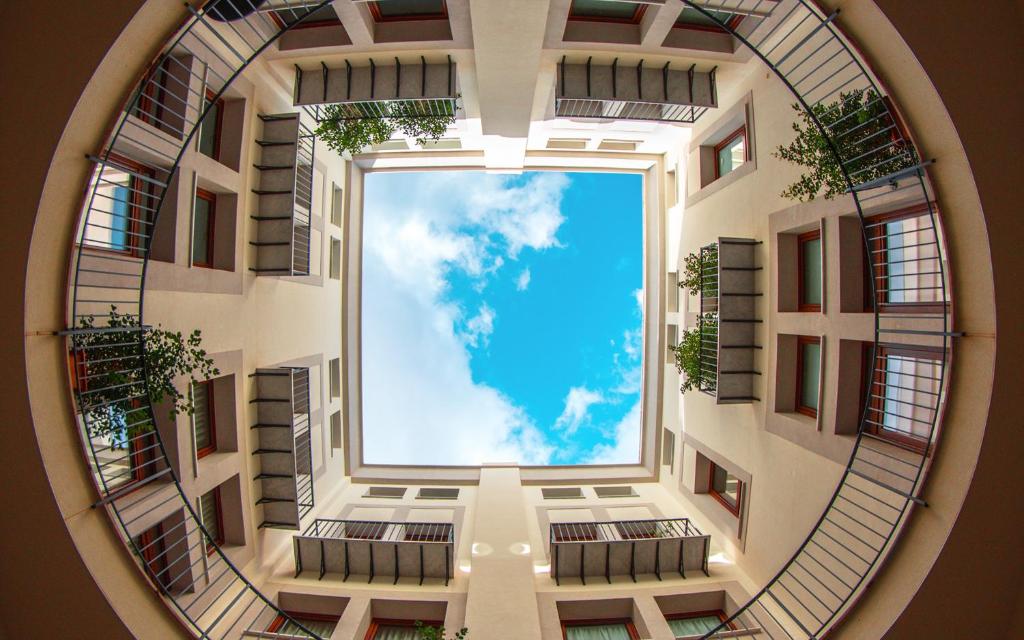 einen Blick vom Inneren eines Gebäudes in den Himmel in der Unterkunft Palermo Blu - Palazzo Quaroni in Palermo