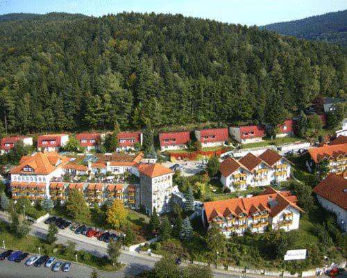 una vista aerea di un resort con edifici e auto di Donna Burghotel am hohen Bogen a Neukirchen beim Heiligen Blut