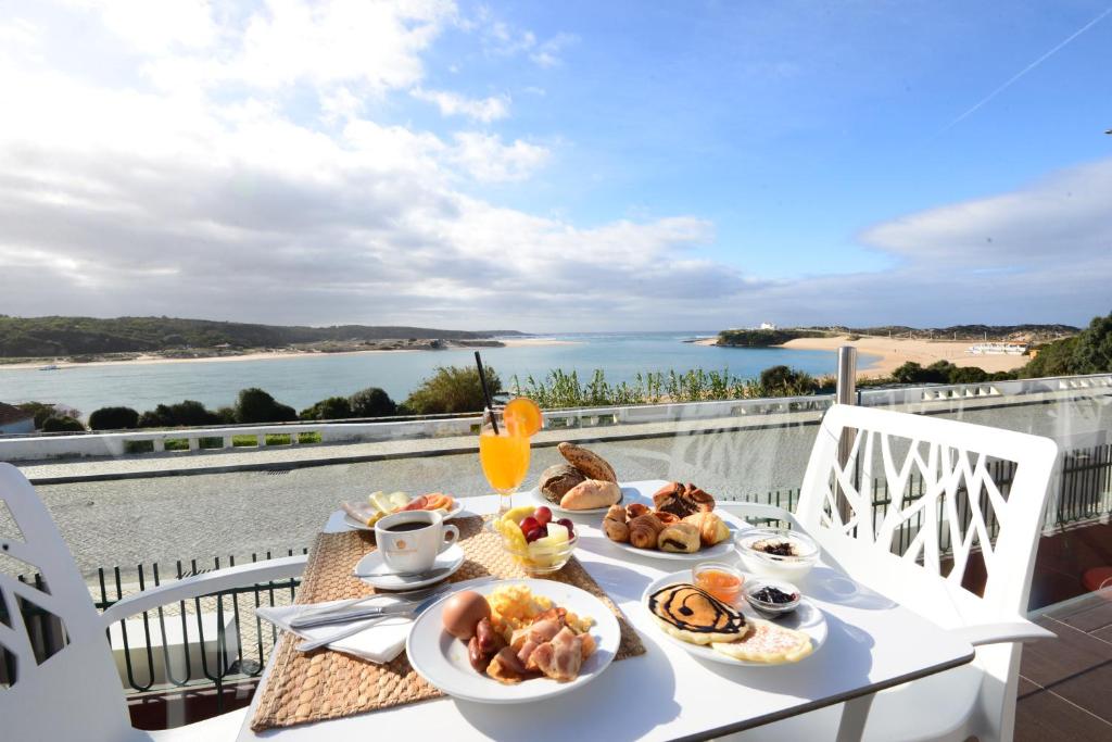 a table topped with plates of food and drinks at Hotel HS Milfontes Beach - Duna Parque Group in Vila Nova de Milfontes