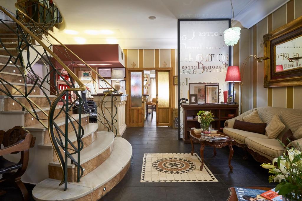 a living room with a spiral staircase and a couch at Casona De Torres in Mondéjar