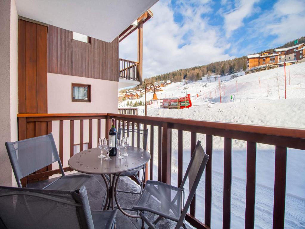 d'un balcon avec une table, des chaises et une piste de ski. dans l'établissement 34 Grande Ourse Vallandry - Les Arcs - Paradiski, à Peisey-Nancroix
