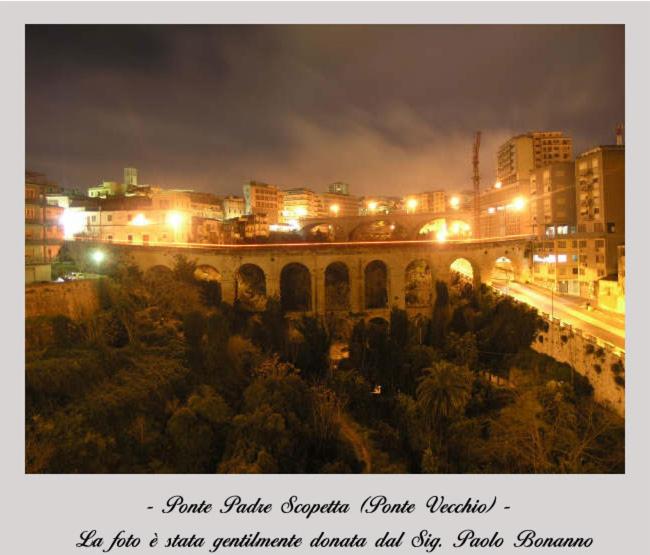 een uitzicht op een stad 's nachts met een brug bij B&B Tarasia in Ragusa
