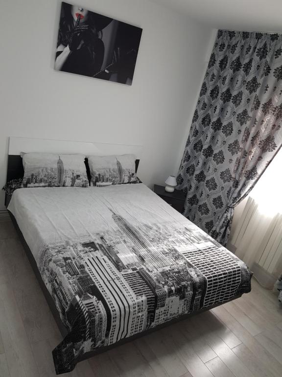 a bedroom with a bed with a black and white blanket at Apartament Flo in Constanţa
