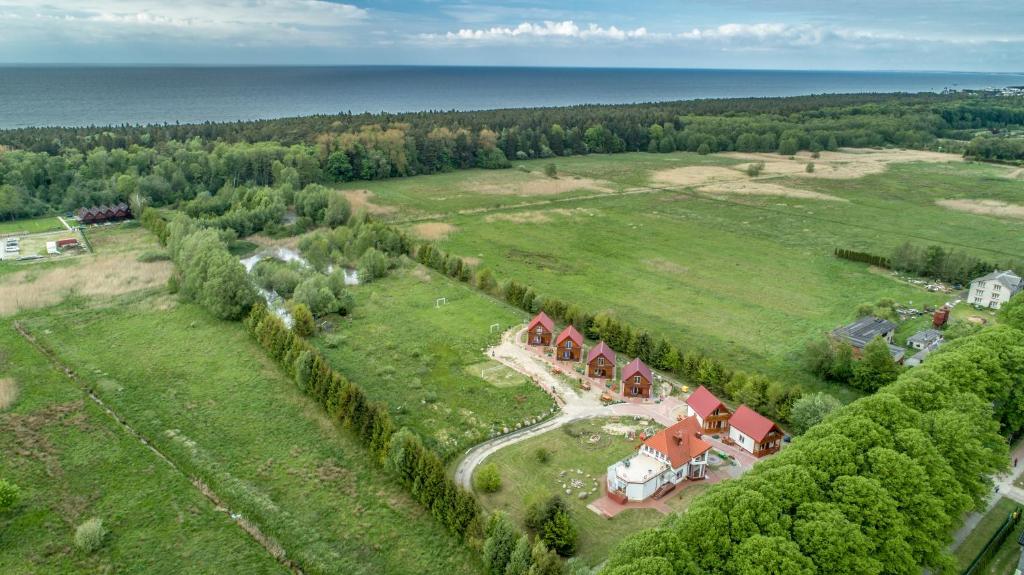 an aerial view of a house in a field with the ocean at Rancho Ohio in Mielno