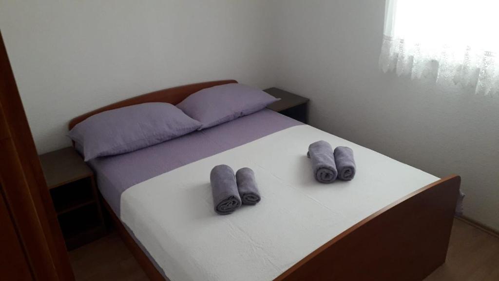 un lit avec deux paires de chaussures en dessus dans l'établissement Apartment Hrgić Vir, à Vir