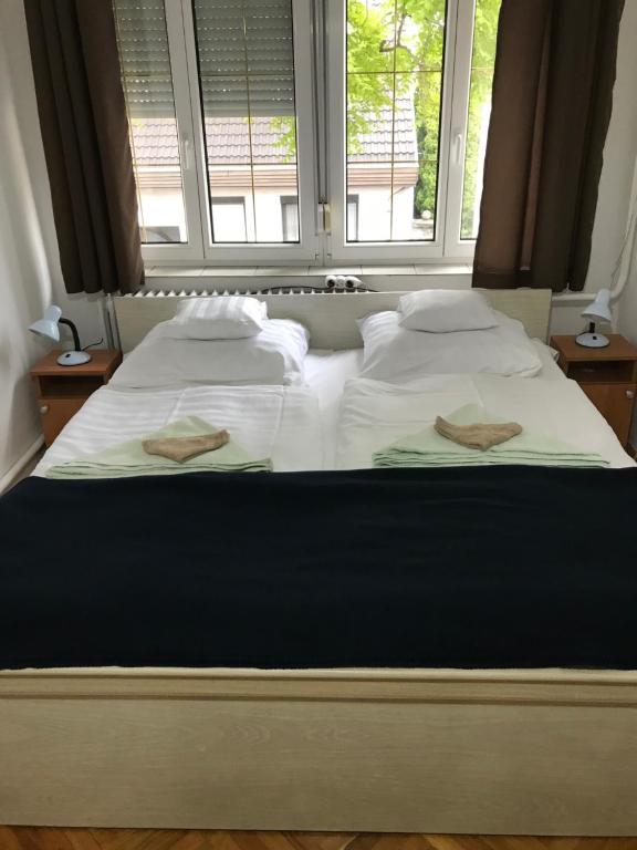 1 cama grande con 2 almohadas y ventana en Hív-Lak Apartman en Eger
