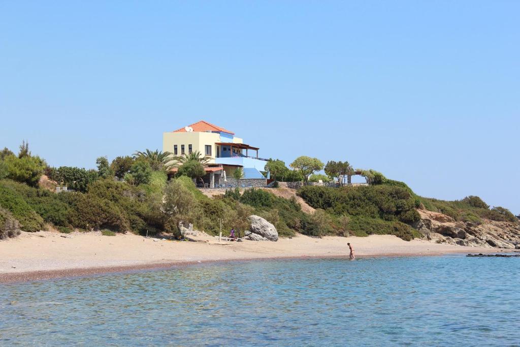 a house on a hill next to a beach at Paraktio Beach Apartments in Kiotari