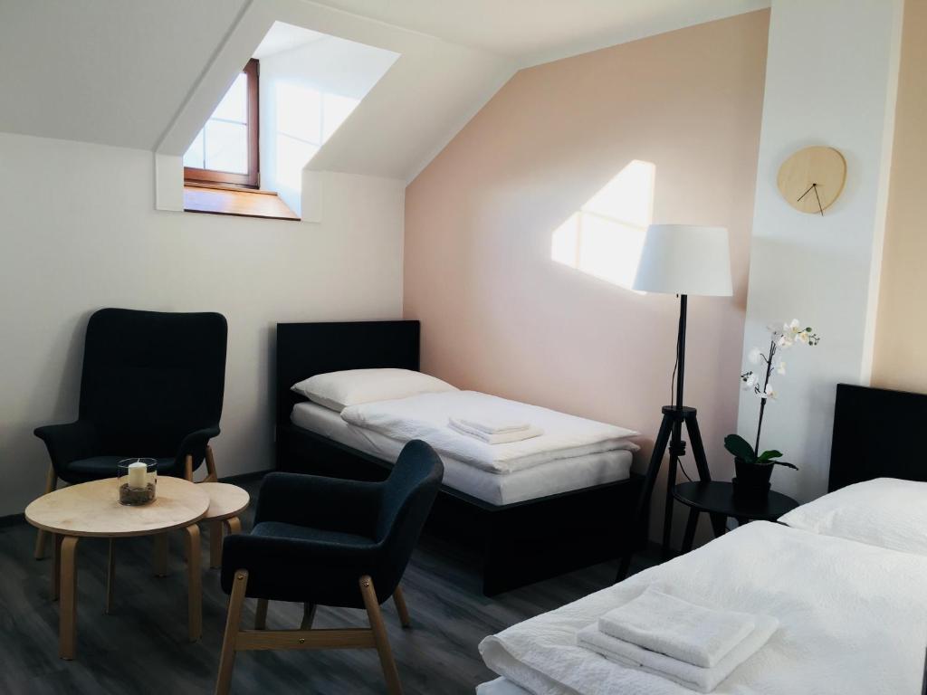 a room with two beds and a table and chairs at Pension na Starém náměstí in Rychnov nad Kněžnou