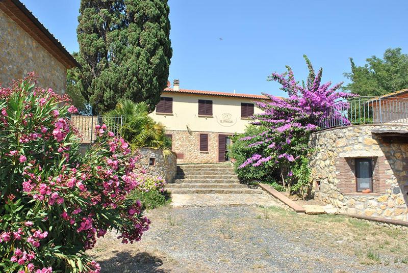 una casa con escaleras y flores delante en Agriturismo Il Poggio, en Casale Marittimo