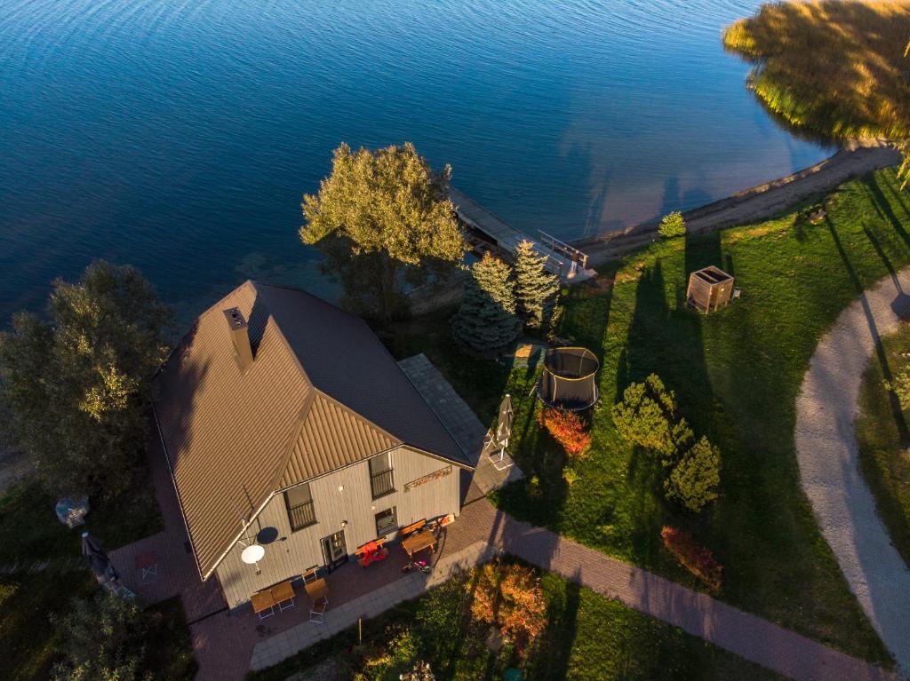 an aerial view of a large house on the water at Vivaldi Lake House in Meteliai