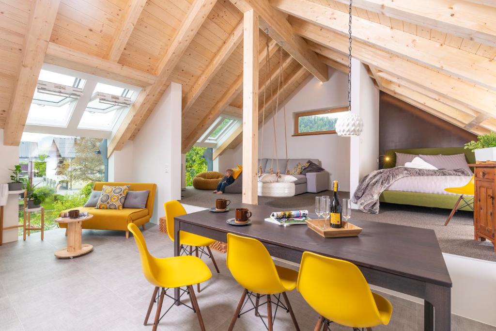 a living room with a dining table and yellow chairs at GIRBL bio APARTMENTS - Lifestyle in Strobl