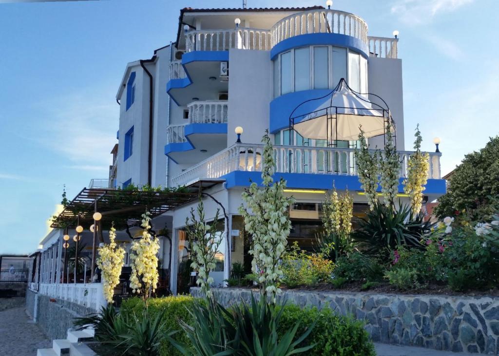 a blue and white building with flowers in front of it at CASA DEL SOL Sozopol in Sozopol
