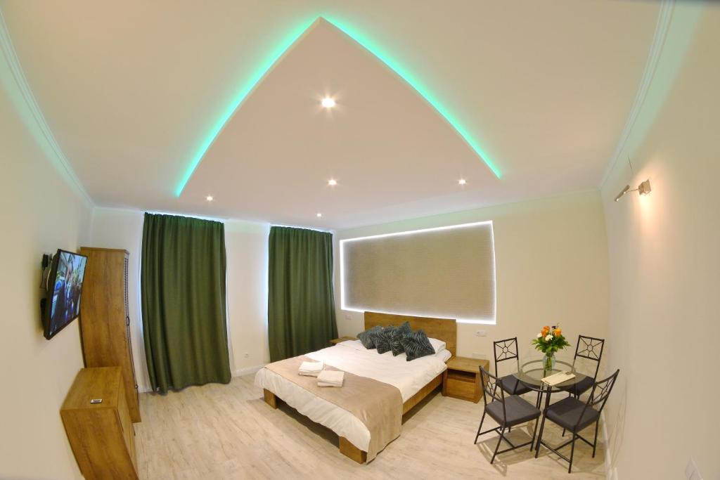 una stanza con un letto e un tavolo con un tavolo sidx sidx sidx di Dimitrie Cantemir Residence a Braşov