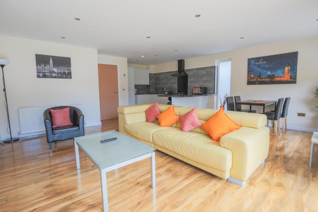 a living room with a couch and a table at Stylish Modern Newly Built Apartment 15 min From City Centre in Edinburgh