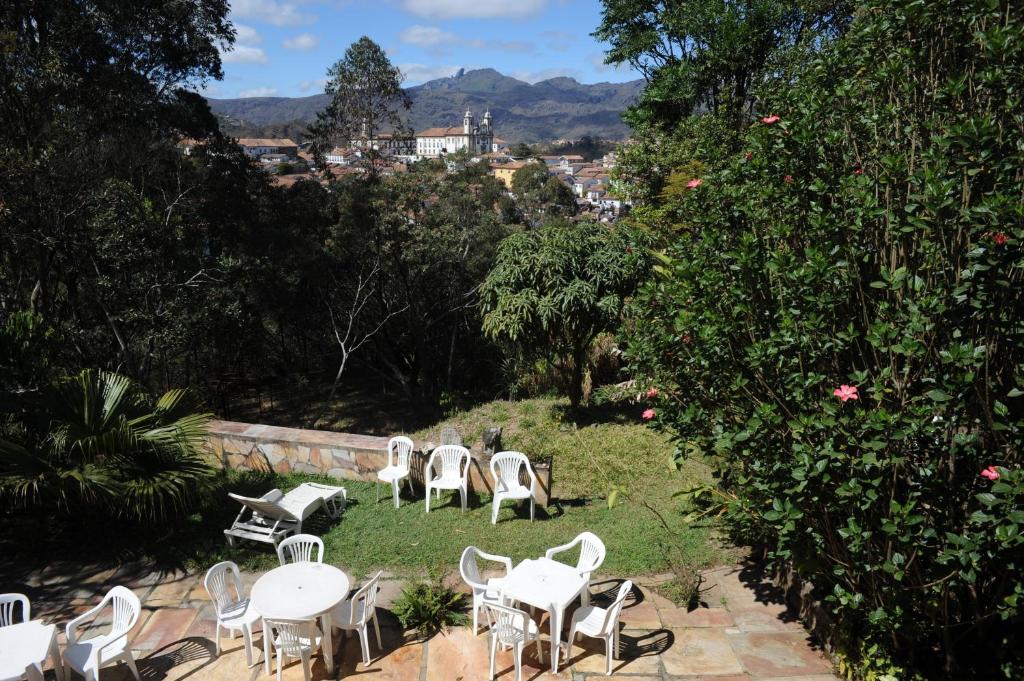 un groupe de chaises et de tables blanches dans une cour dans l'établissement Pousada São Francisco de Paula, à Ouro Preto