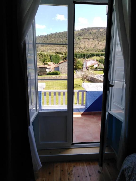 an open door to a balcony with a view of a yard at La Clinica in Ballota
