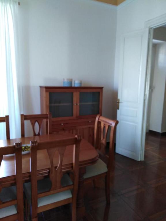 a dining room with a wooden table and chairs at La Clinica in Ballota