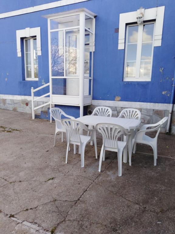 a table and chairs in front of a blue building at La Clinica in Ballota