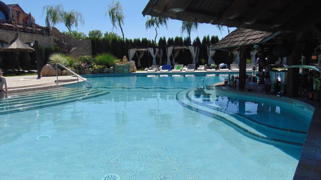 a large swimming pool with blue water in a resort at Castel Transilvania in Baia Mare