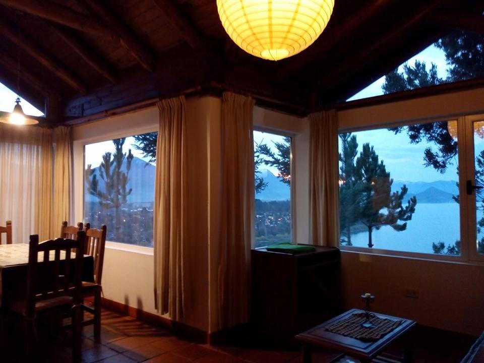 a dining room with large windows and a table and chairs at Aucapillan in San Carlos de Bariloche