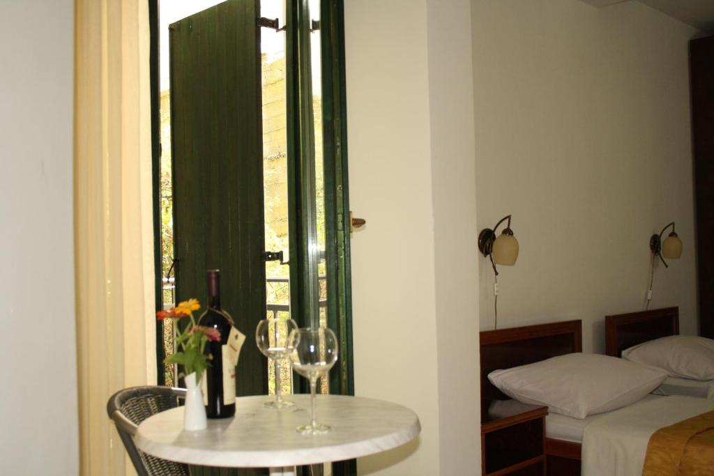 a room with a table with wine glasses and a window at Hotel Danica in Petrovac na Moru