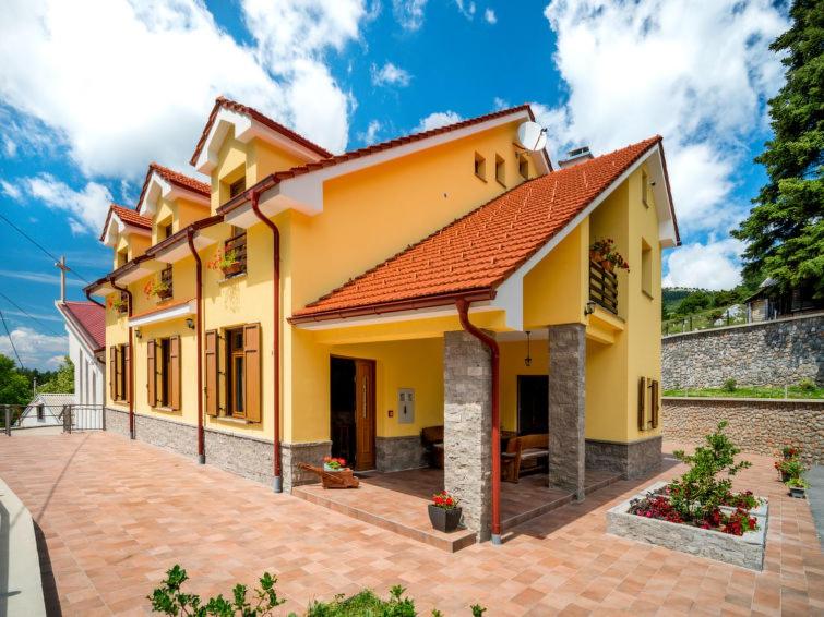 a yellow house with a red roof at Apartments Oltari in Sveti Juraj