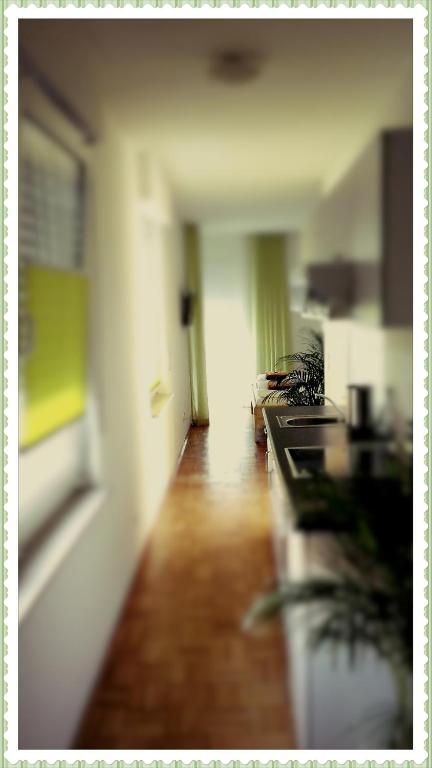a room with a kitchen with a counter and a hallway at Pension Zeitlos in Potsdam
