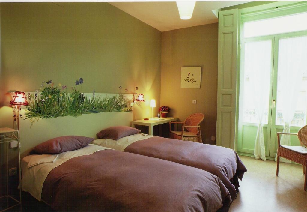 - une chambre avec 2 lits, une table et une fenêtre dans l'établissement Hostal Fornos, à Ségovie