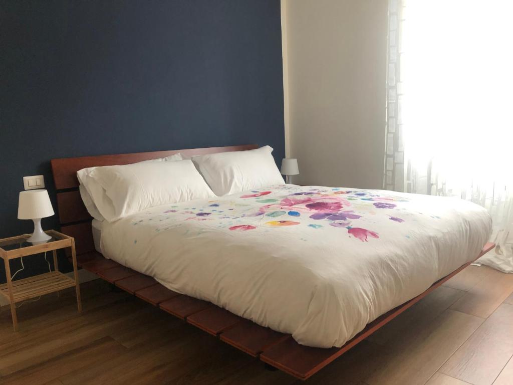 a bedroom with a bed with a white comforter and a window at Vivi Cernobbio, la sua arte, la sua magia in Cernobbio