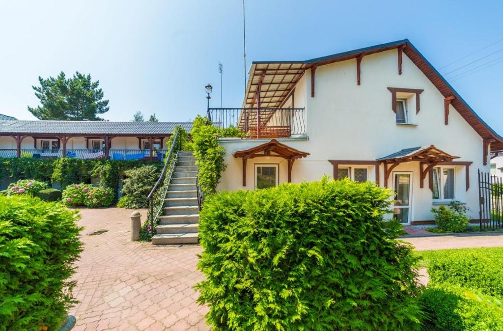a house with a staircase in front of it at Pokoje Olech in Wrzosowo