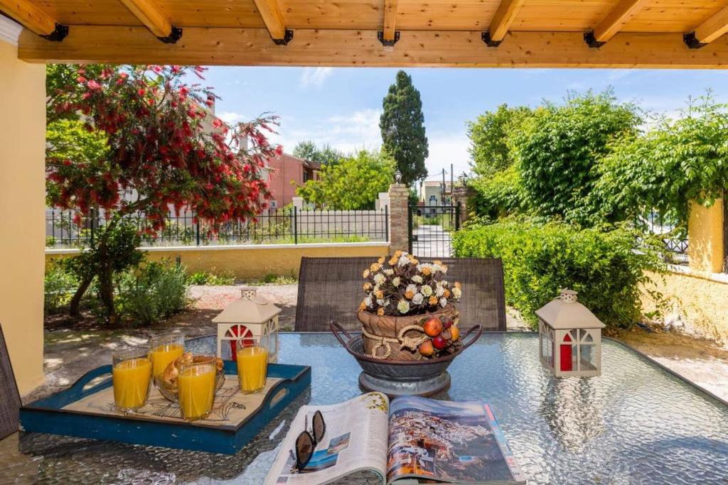 a patio table with a bowl of fruit and orange juice at Maria's Countryside House in Corfu