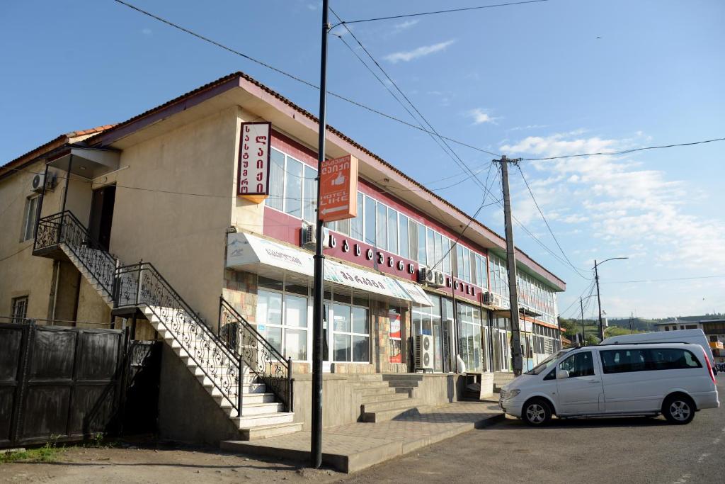 a white van parked in front of a building at Hotel Like in Akhaltsikhe