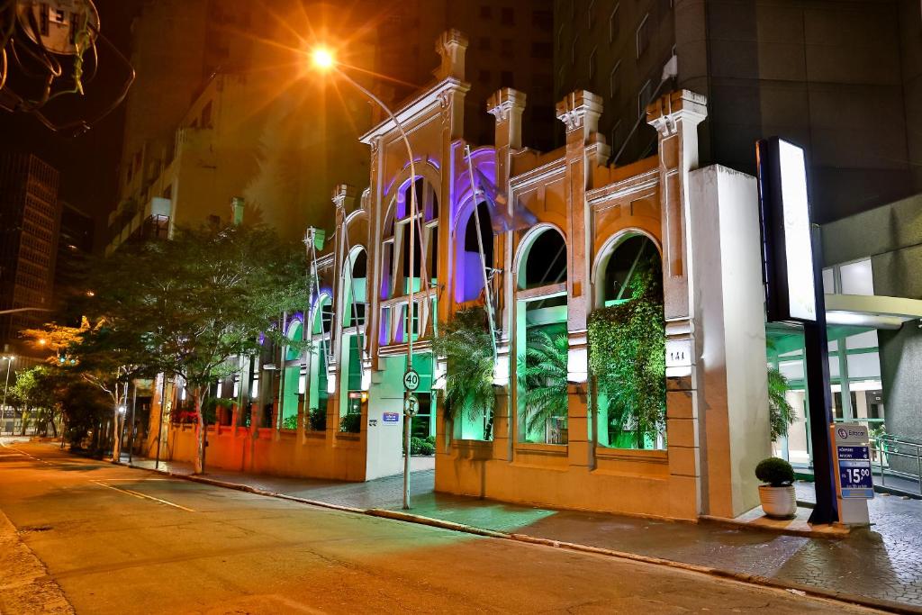 a building with colorful lights on a street at night at Slaviero São Paulo Downtown in São Paulo