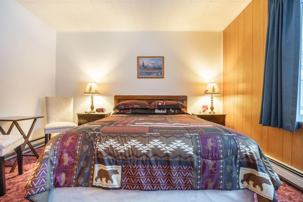 a bedroom with a bed with a colorful bedspread at Talkeetna Inn in Talkeetna