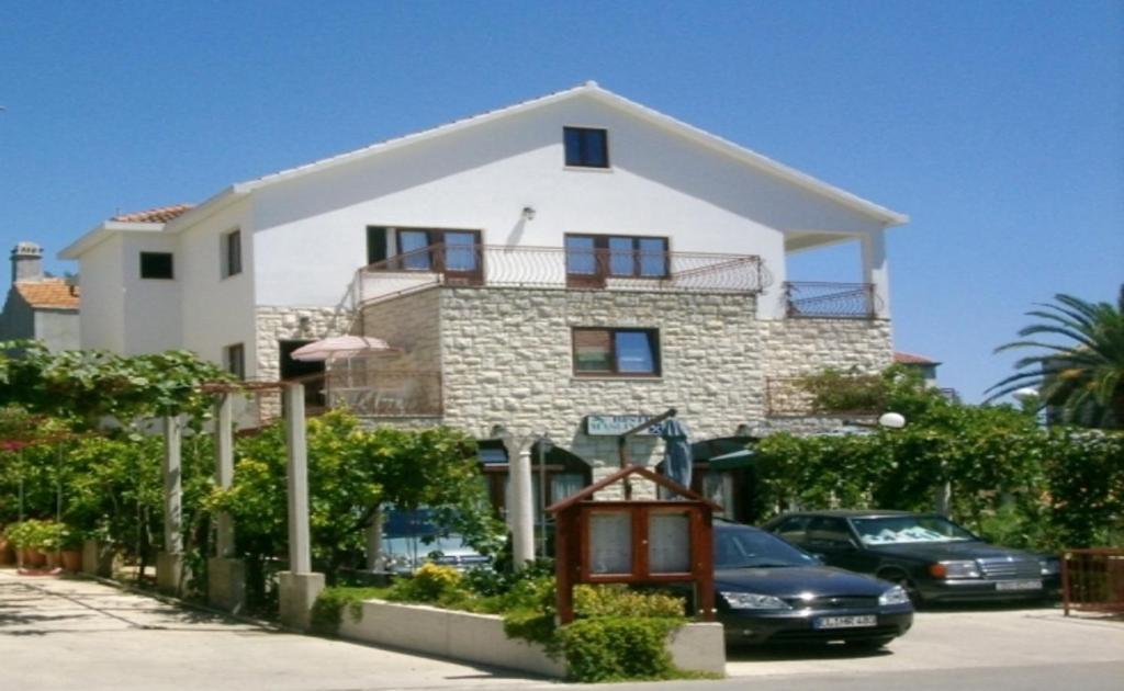 una casa grande con coches estacionados frente a ella en Apartments Miho en Orebić