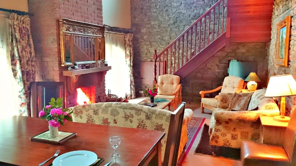 sala de estar con mesa y chimenea en Kilmokea Coach House en New Ross