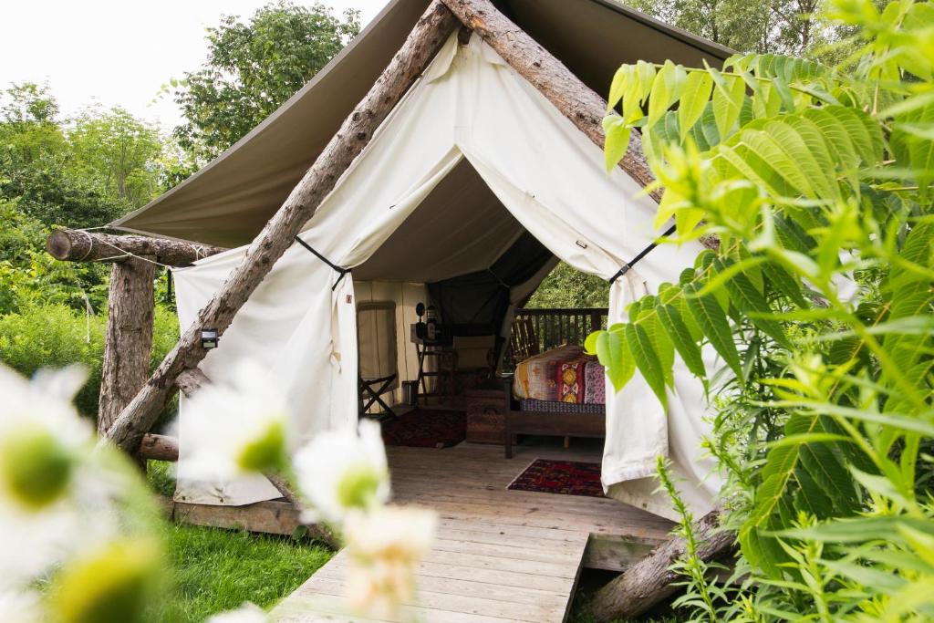 a canvas tent with a bed in a garden at Firelight Camps in Ithaca