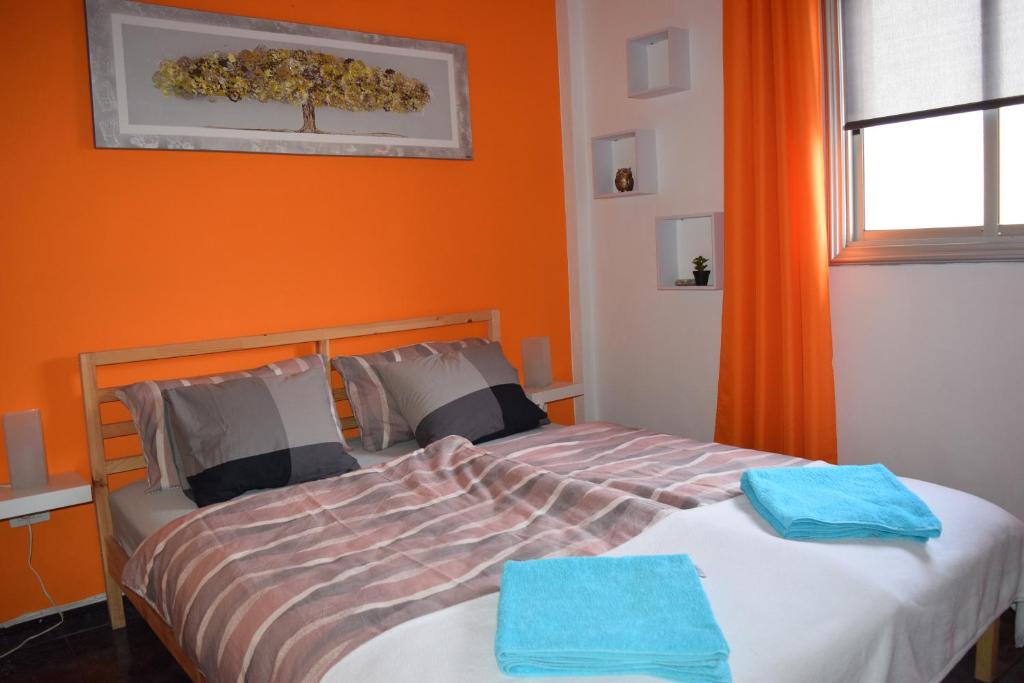 2 camas en un dormitorio con pared de color naranja en B&B La Caleta Zimmer 2, en La Mareta