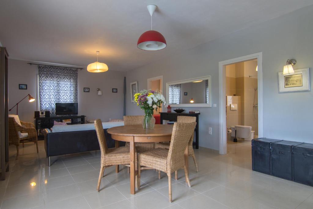 a dining room and living room with a table and chairs at Villa Elaia Suites & Apartments No.2 in Gaios