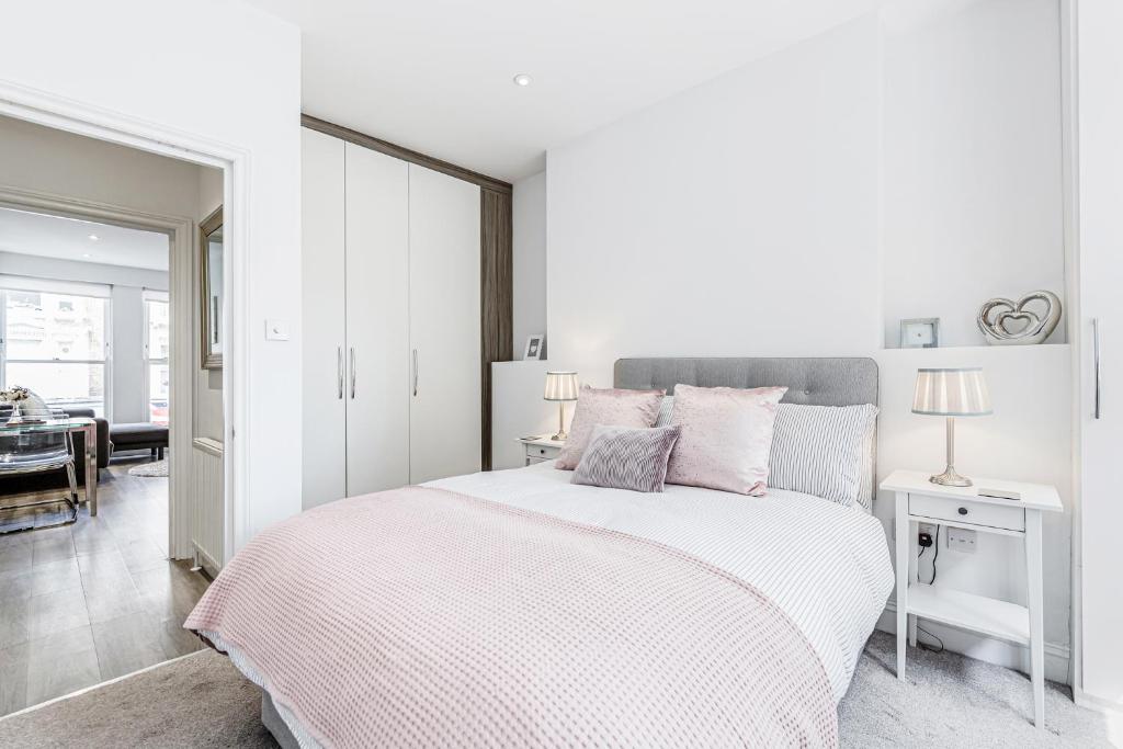 a white bedroom with a bed and a dining room at 2-bed Notting Hill / Portobello in London