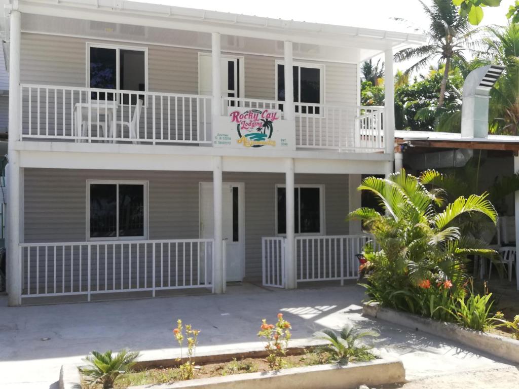 Casa grande con terraza blanca y balcón. en Rocky Cay Lodging en San Andrés