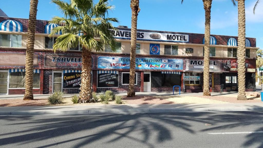 a hotel with palm trees in front of it at Travelers Bed & Breakfast Hostel in Las Vegas