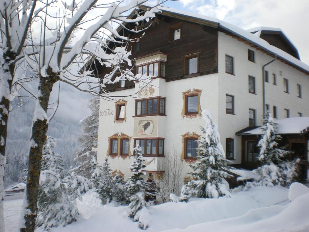 a building in the snow with snow covered trees at Hotel Zita in Trins