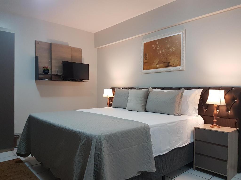 a bedroom with a bed and two lamps and a tv at B & A Suites Inn Hotel - Quarto Luxo Diamond in Anápolis