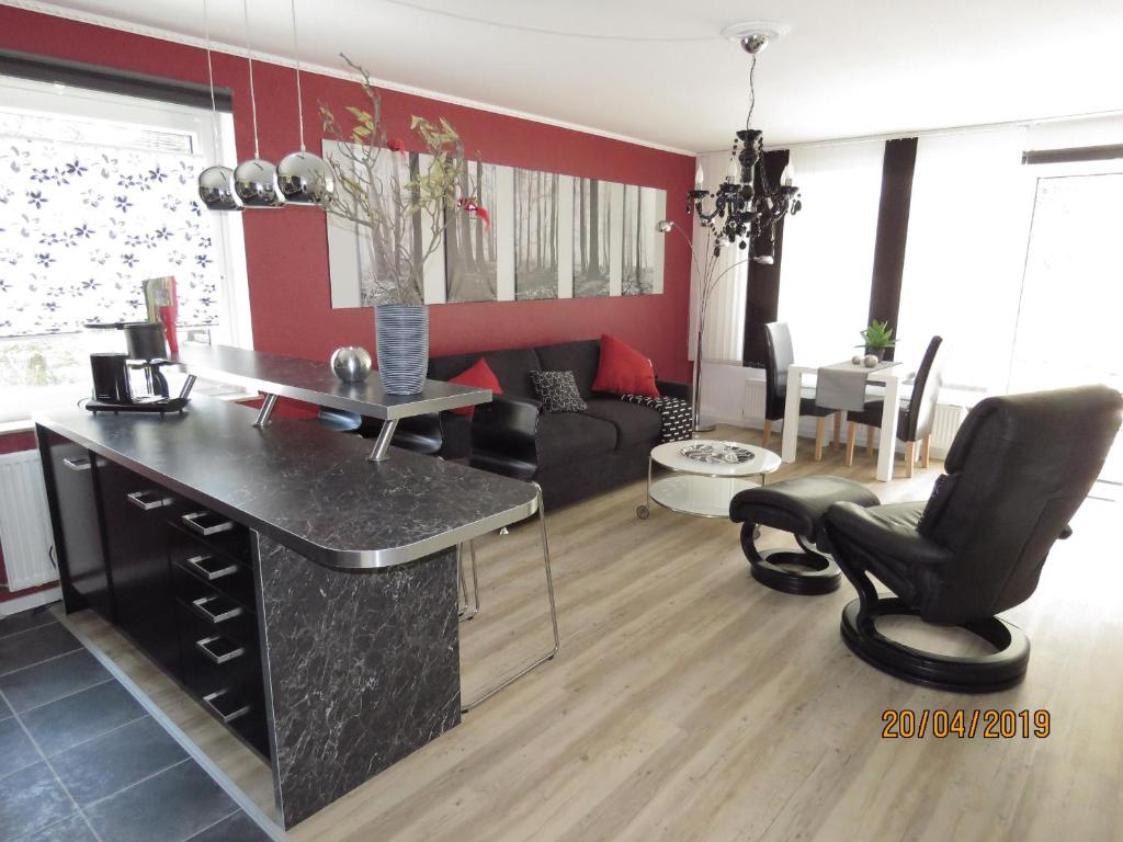cocina y sala de estar con encimera negra en Fewo Am Wald 5, en Hahnenklee-Bockswiese