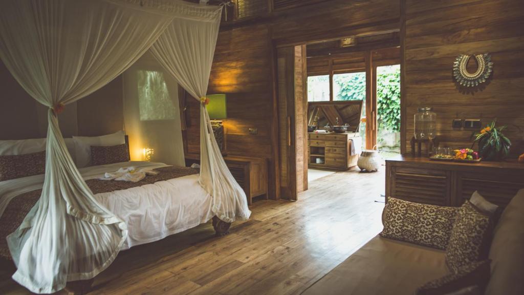 1 dormitorio con 1 cama con mosquitera en Desa Saya Eco Luxury Resort & Spa, en Tejakula