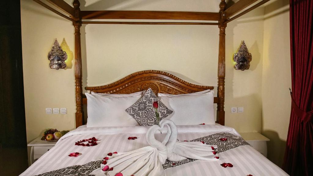 Postel nebo postele na pokoji v ubytování Kampoeng Joglo Boutique Hotel